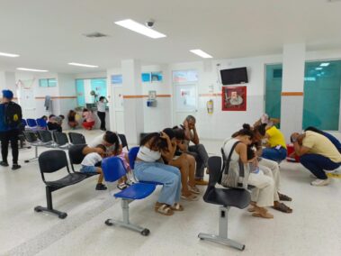 Usuarios de MiRed IPS practican medidas de autoprotección cubriéndose la cabeza en una sala de espera durante el Simulacro Nacional de Emergencias 2026.