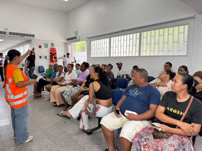 Brigadista de MiRed IPS orienta a usuarios en una sala de espera durante el Simulacro Nacional de Emergencias 2026.